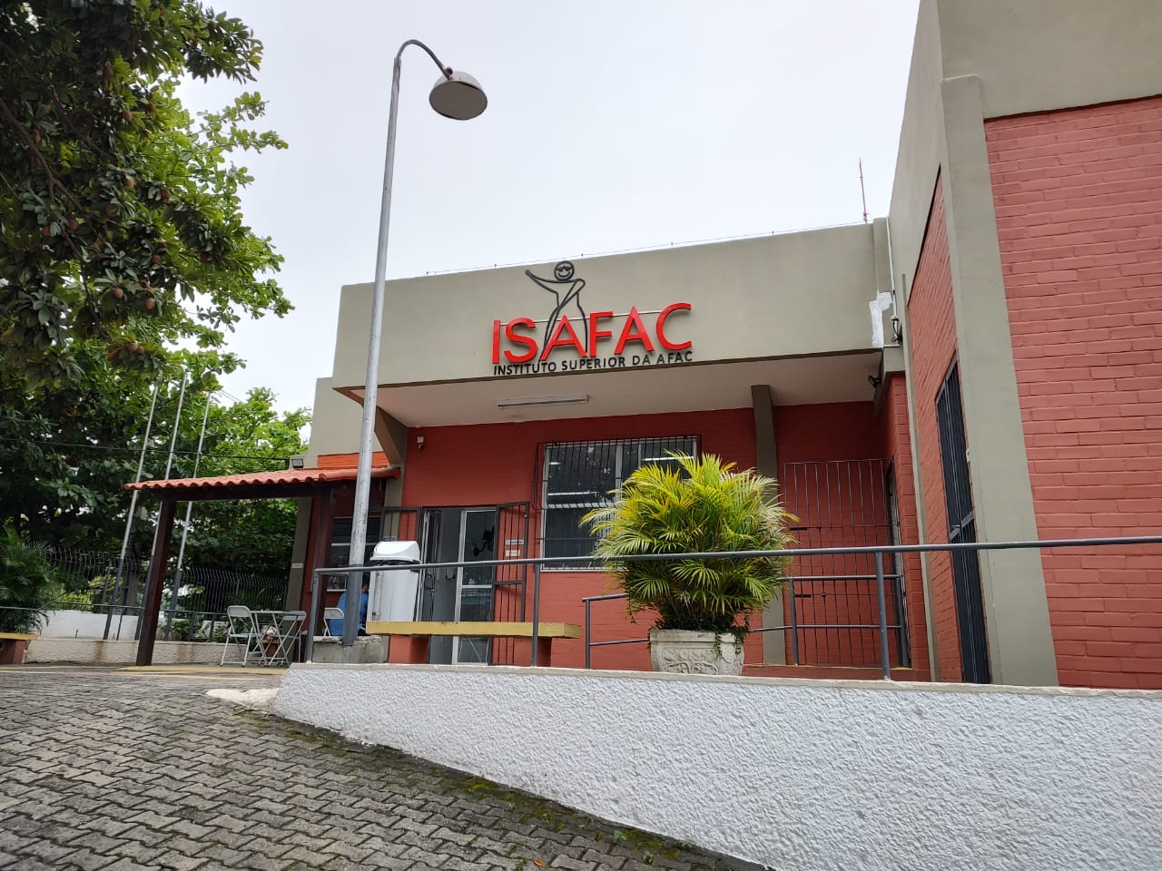 Foto do Instituto Superior da AFAC. A foto mostra a entrada ISAFAC, a esquerda da foto tem a lanchonete e a direita a biblioteca